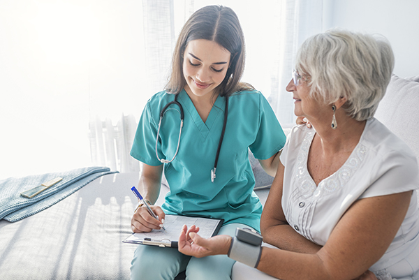 Nurse checking elderly woman's blood pressure